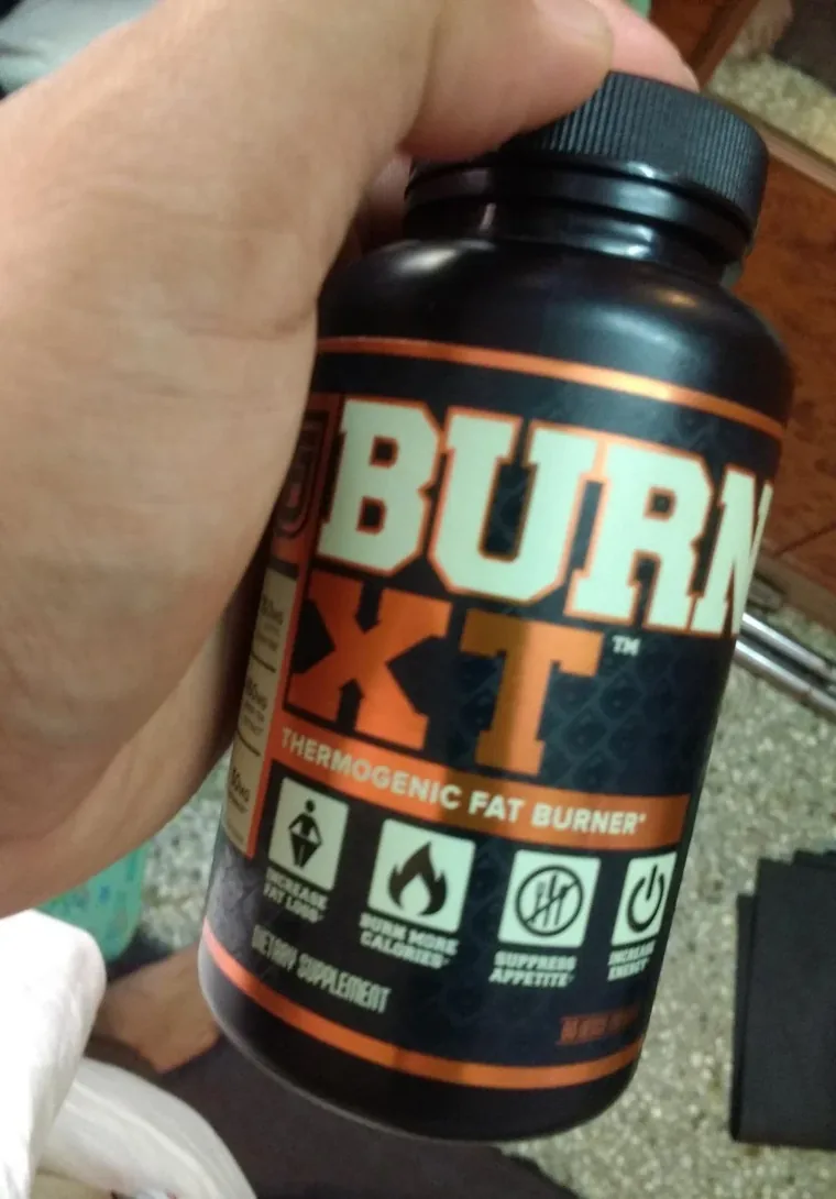 A Burn XT bottle held in one hand, photographed in natural light